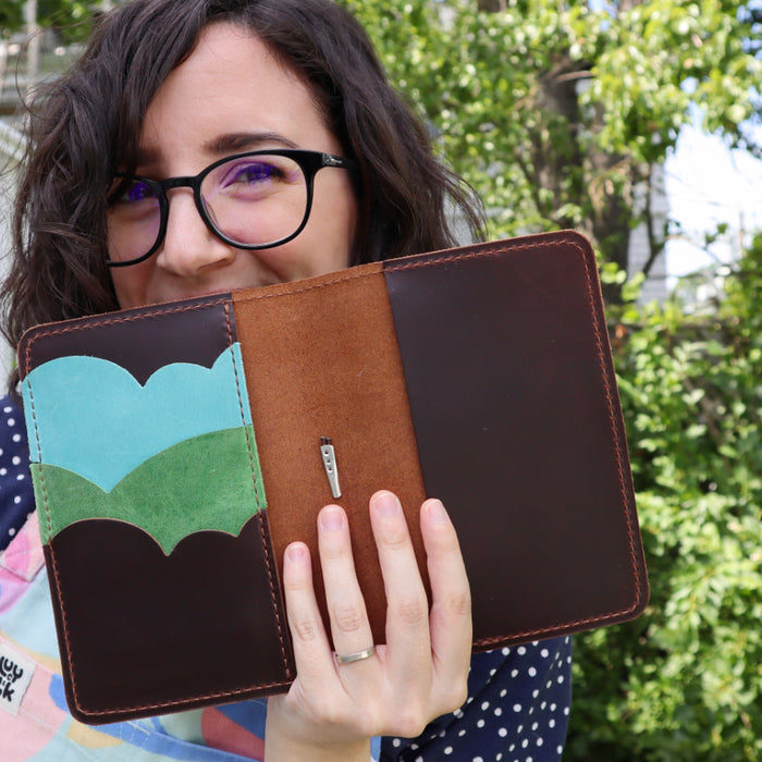 Model with a leather notebook in his hands.