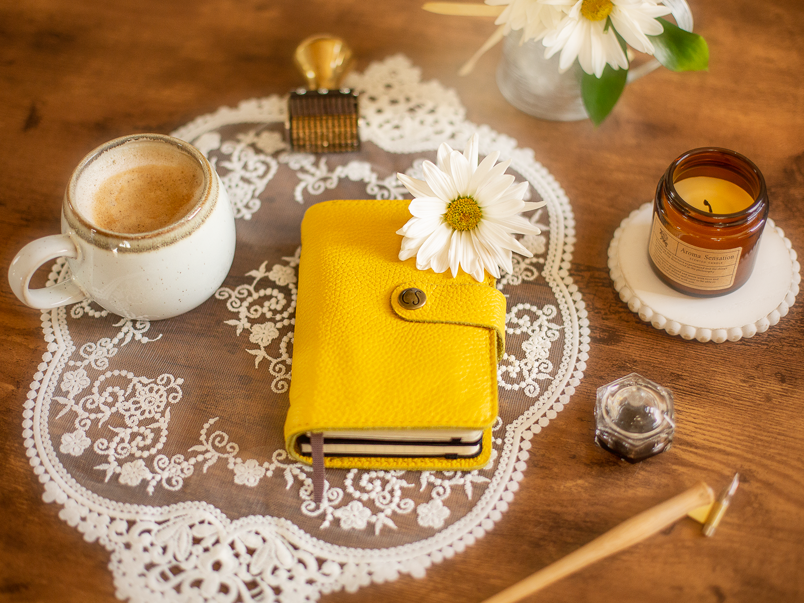 A leather notebook on a table with some arrangements.