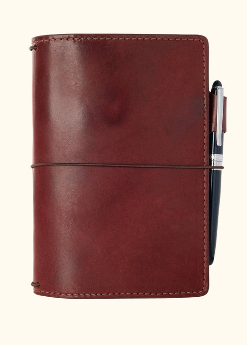 An Austen leather notebook with a closure elastic and pen loop. The collection name is Austen and the color is called Drummond (Burgundy) - ChicSparrow