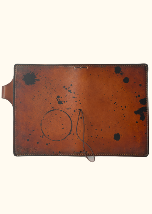 This is an example of what antiquing looks like on a Darcy. Antiquing is when an artist applies dye to make markings like splatters and cup rings on a leather notebook to make it look older. - ChicSparrow