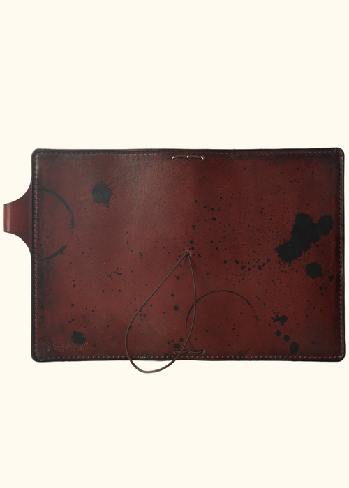 This is an example of what antiquing looks like on a Drummond. Antiquing is when an artist applies dye to make markings like splatters and cup rings on a leather notebook to make it look older. - ChicSparrow