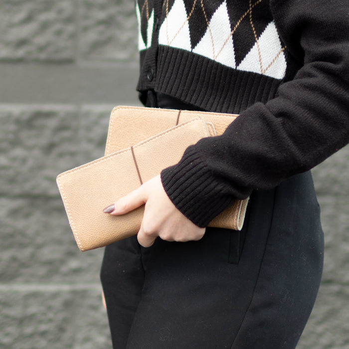Women holding our June Newsletter: New Dundee, Cardholder, Meteorite Set
