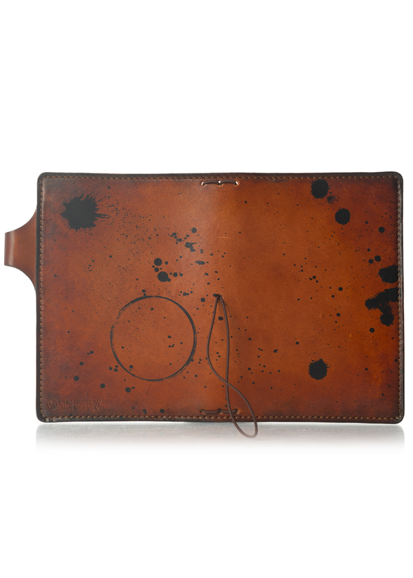 This is an example of what antiquing looks like on a Darcy. Antiquing is when an artist applies dye to make markings like splatters and cup rings on a leather notebook to make it look older. - ChicSparrow