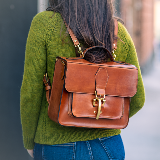  a woman in a  with a Leather satchel configured as a backpack.