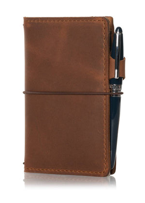 Brown leather travelers notebook journal cover with elastic closure.