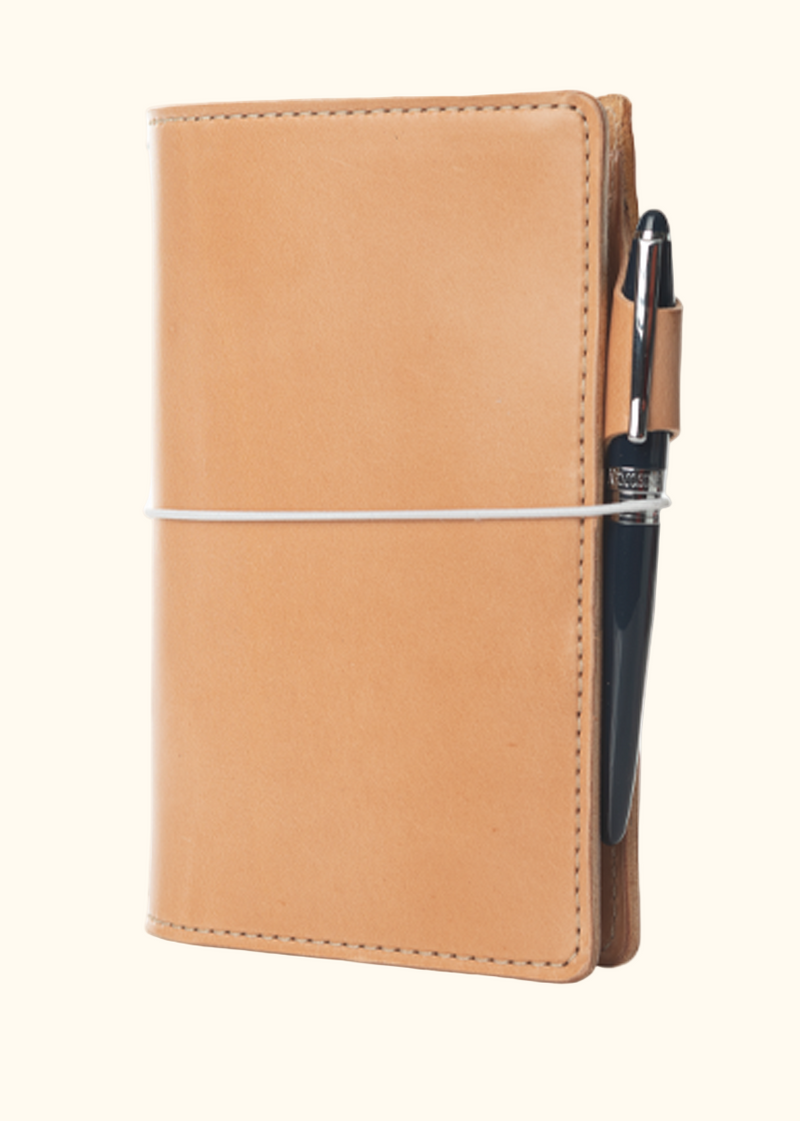 An Austen leather notebook with a closure elastic and pen loop. The collection name is Austen and the color is called Emma (Buff) - ChicSparrow
