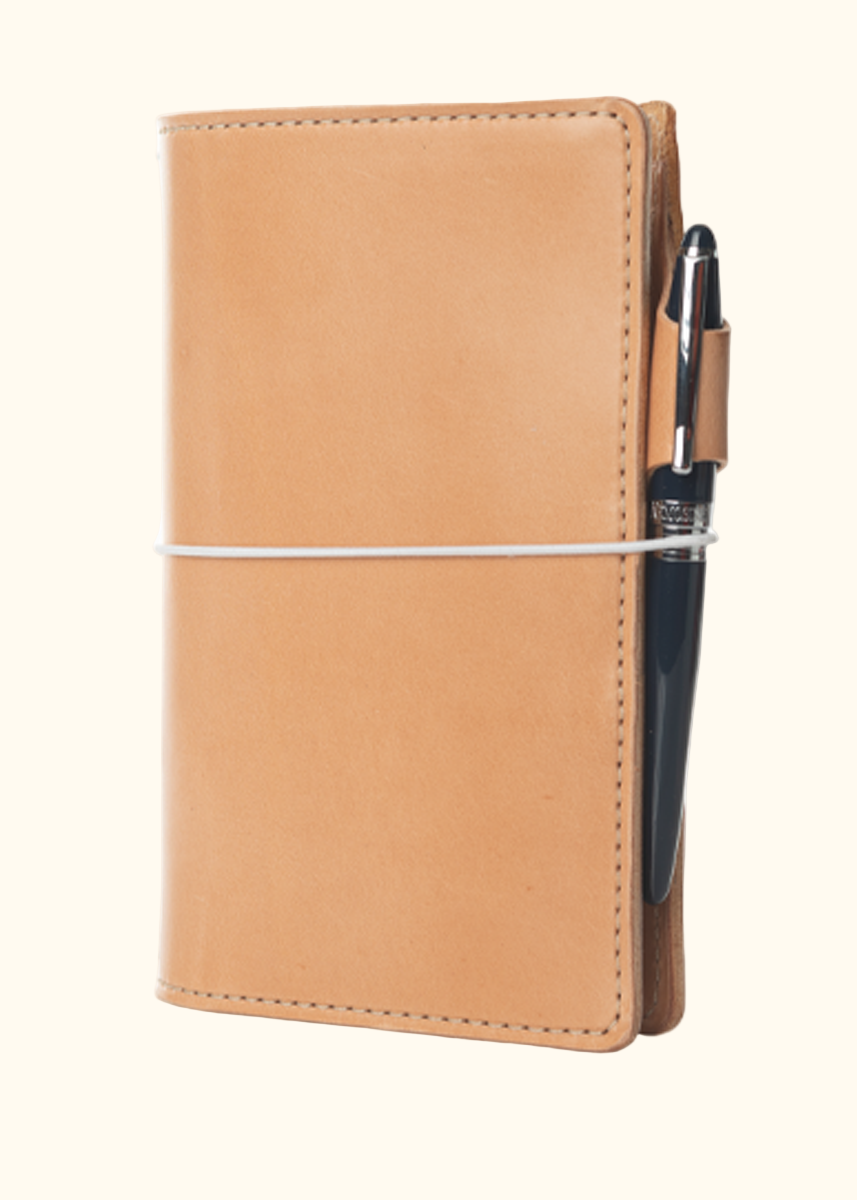 An Austen leather notebook with a closure elastic and pen loop. The collection name is Austen and the color is called Emma (Buff) - ChicSparrow