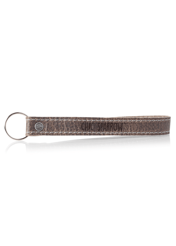 Leather key fob with Chic Sparrow logo. Leather keychain with key ring and rivet.